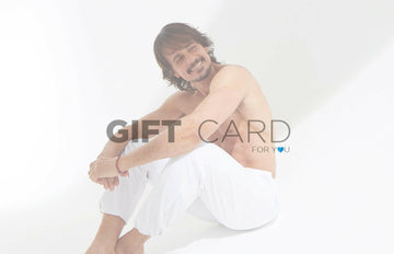 Imagen de hombre sentado de fondo blanco sonriente con un texto sobre impreso que dice GIFT CARD FOR YOU
